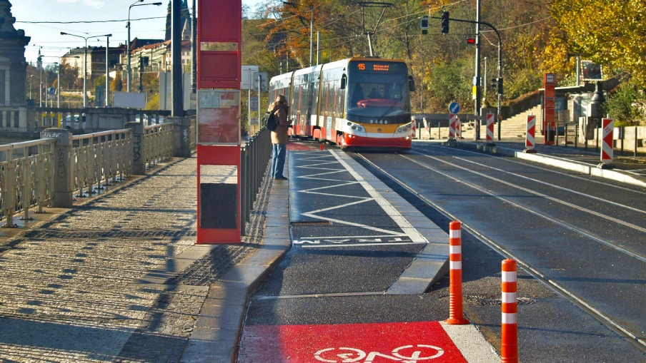 Tramvaj přijíždějící k nově upravené bezbariérové tramvajové zastávce "Čechův most" v Praze.